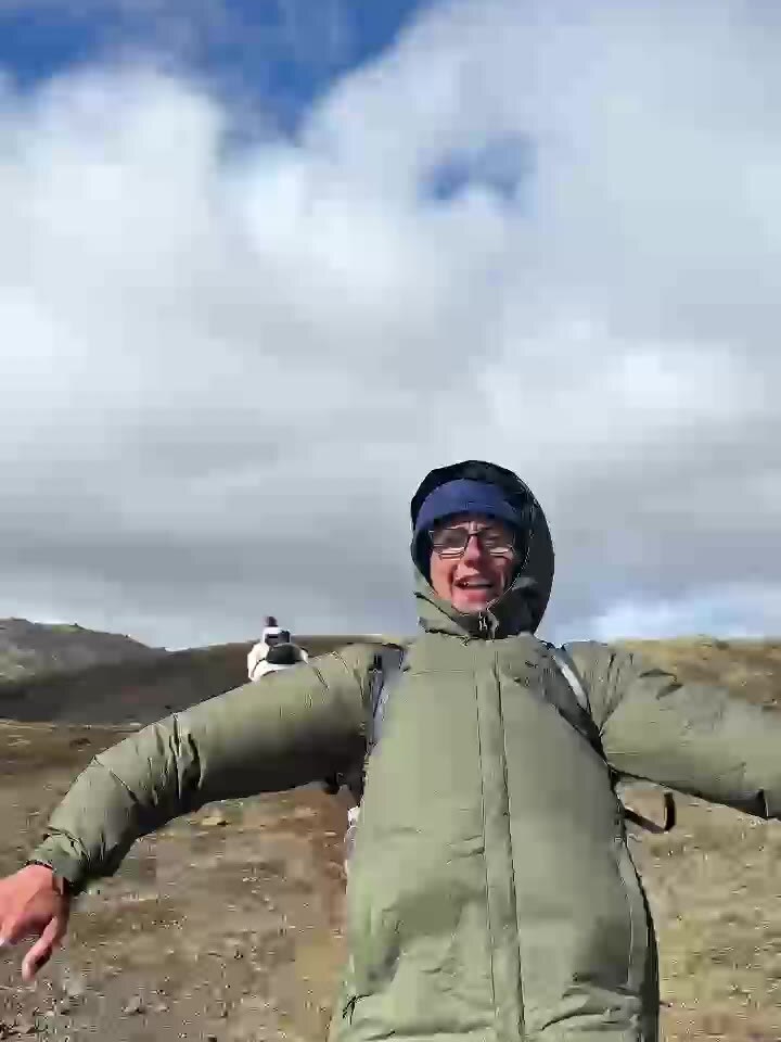 A traveller on a mountain trail, arms wide